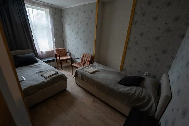 Host house room with two beds and armchairs