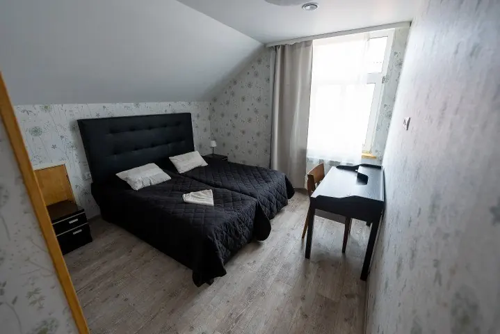 Host house bedroom with a dark bedspread and desk