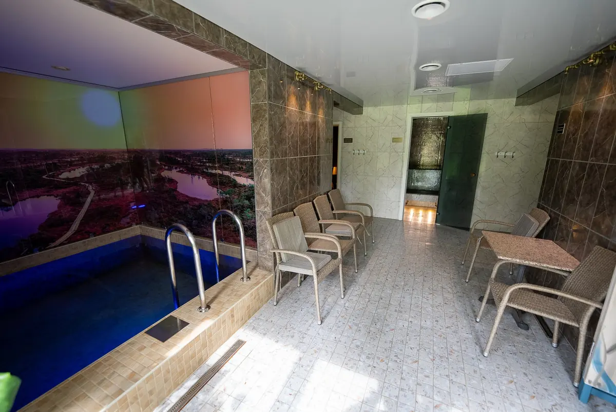 Cold plunge pool and lounge chairs in blue light