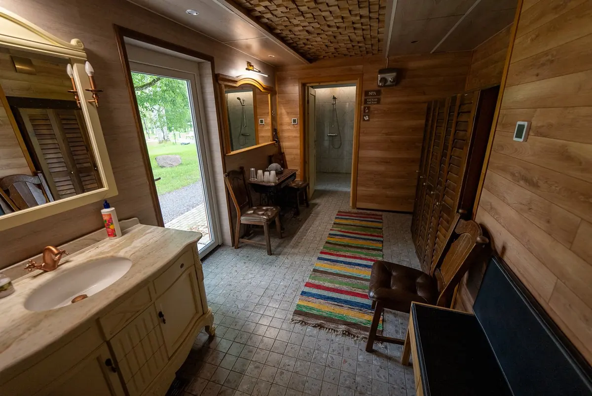 Spa entrance room with washbasin, mirror and wooden walls