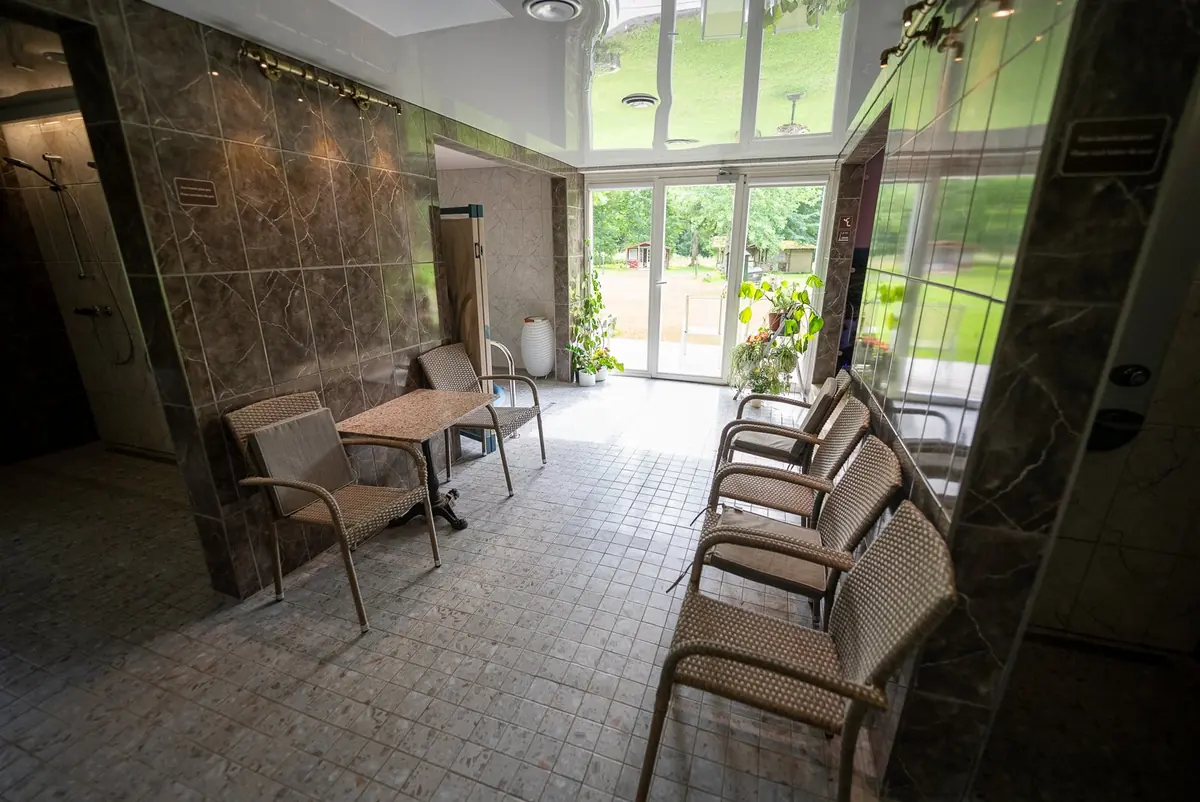 Spa lounge with chairs and large windows facing the garden