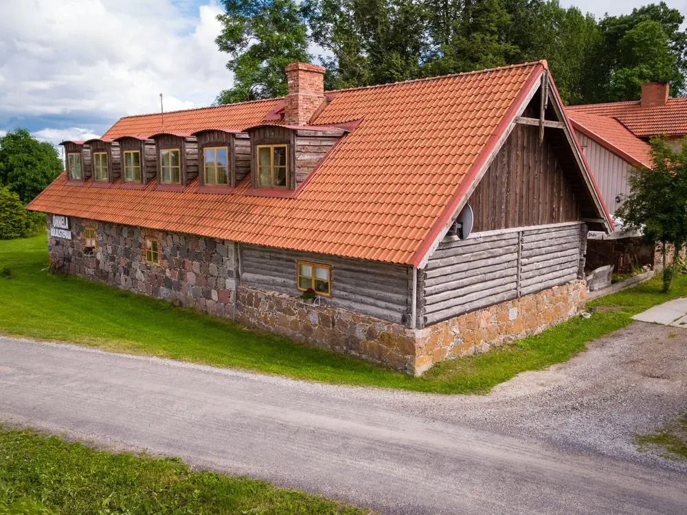 Õnnela guesthouse, a fieldstone and log building with dormer windows