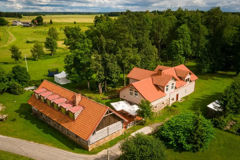 Aerial view of the Õnnela guesthouse and host house with red roofs and park
